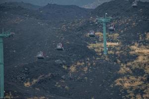 View of cable cars moving over volcanic landscape of Mount Etna photo