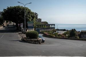 coches que circulan por la carretera en la antigua ciudad costera con el cielo de fondo durante el verano foto