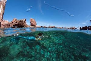 Mermaid swimming underwater in the deep blue sea photo