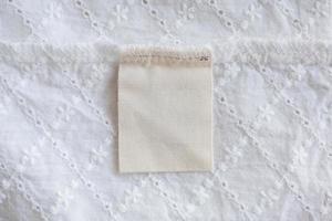 blank laundry care clothes label on fabric texture background photo