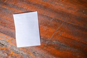 Blank white paper on old rustic wood table background photo