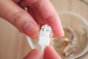 Jeweller hand cleaning and polishing vintage jewelry diamond ring closeup photo