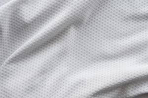 camiseta de fútbol de ropa deportiva de tela blanca con fondo de textura de malla de aire foto
