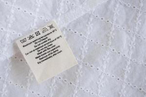 laundry care washing instructions clothes label on fabric texture background photo