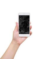 hand hold mobile phone with broken glass screen display isolated on white background photo