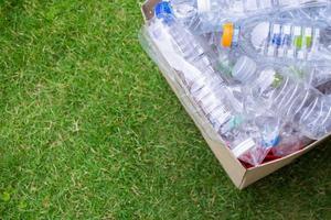 botellas de plástico en caja de basura de reciclaje marrón foto