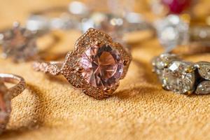 Jewelry pink diamond rings on golden fabric background close up photo