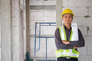 trabajador de ingeniero de construcción de hombre de negocios asiático en el sitio de construcción de viviendas foto