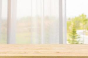 Empty wood table top with window curtain abstract blur background for product display photo