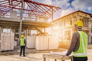 trabajador de ingeniero de construcción de hombre de negocios asiático en el sitio de construcción de viviendas foto