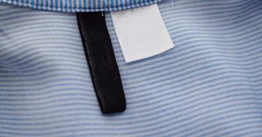 etiqueta de ropa en blanco y negro sobre fondo de textura de tela azul foto