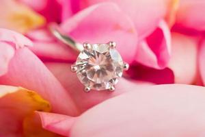 Jewelry diamond ring on beautiful pink rose petal background photo