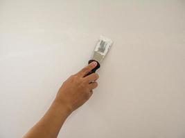 Plasterer hand repair crack white wall photo