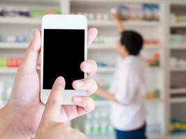 women using smart phone in pharmacy blurred background photo