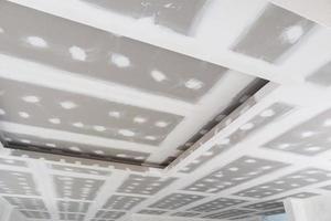 ceiling gypsum board installation at construction site photo