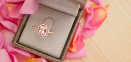 elegant wedding diamond ring in jewelry box on beautiful pink rose petal background close up photo