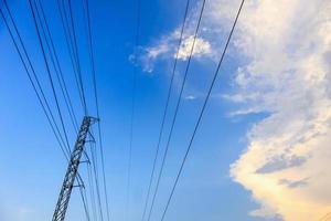 High voltage towers electric lines with clouds and sky photo