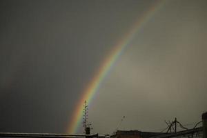 Rainbow in sky. Refraction of light. Weather after rain. Bright arc of different colors. photo