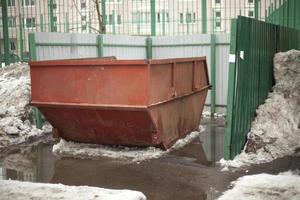 Garbage container. Steel waste tank in city. Large garbage can in yard. photo