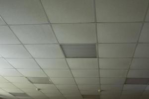 Ceiling is made of tiles in building. Interior of office is in detail. photo