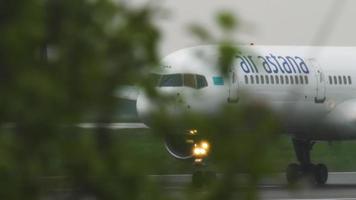 almaty, cazaquistão, 4 de maio de 2019 - air astana boeing 757 p4 freando a gás após pousar na pista em tempo chuvoso. aeroporto de almaty, cazaquistão video