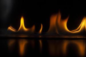 Flames in dark. Tongue of fire. Ignition of alcohol. Burning alcohol on black background. photo