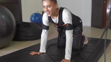 Young woman wears electrodes suit for physical therapy video