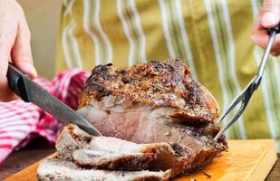 Baked pork meat with spices on wooden cutting board photo