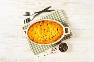 Shepherd's Pie or Cottage Pie, traditional British dish on white wooden background photo