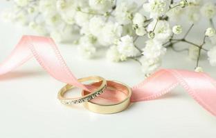 Wedding Concept Accessories with Wedding Rings and White Flower Background photo