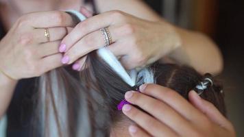 meninas trançando o cabelo com um fio de cabelo branco video