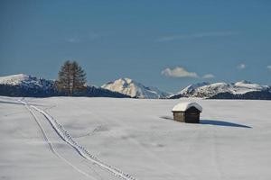 una cabaña de madera en el fondo de la nieve invernal foto