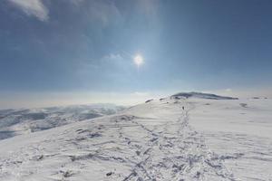 High mountain sunny view with isolated hiker on trail photo