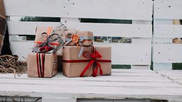 tas de cadeaux de noël sur un banc à l'extérieur