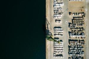 Aerial drone top down view of containers and concrete blocks spread across a busy port, logistic and international trade concept photo