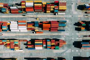 Aerial drone top down view of containers spread across a busy port, logistic and international trade concept photo