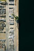 Aerial drone top down view of containers and concrete blocks spread across a busy port, logistic and international trade concept photo