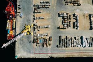 Aerial drone top down view of containers and concrete blocks spread across a busy port, logistic and international trade concept photo