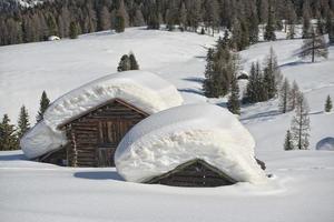 Isolated wood mountain house cabin hut covered by snow photo