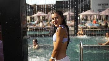 giovane donna nel costume da bagno assunzione doccia a acqua parco video