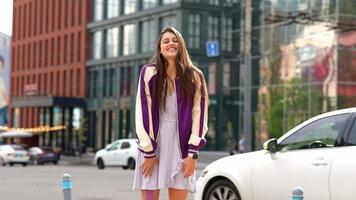 fille portant une robe violette dans la rue par une journée ensoleillée video
