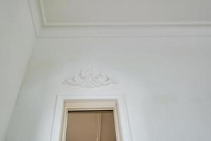 corner of ceiling cornice with intricate crown molding. photo