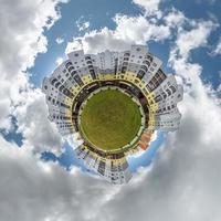 tiny planet in blue sky with clouds in city center near modern skyscrapers or office buildings. Transformation of spherical 360 panorama in abstract aerial view. photo