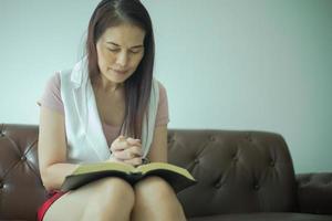 mujer asiática cree en la oración a dios. concepto de estudio bíblico y cristiano.