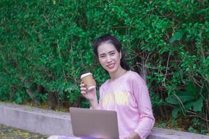 Asian woman working on laptop outdoor, lifestyle concept.