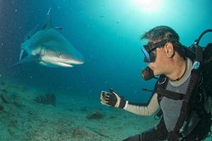 selfie bajo el agua con un tiburón gris listo para atacar foto