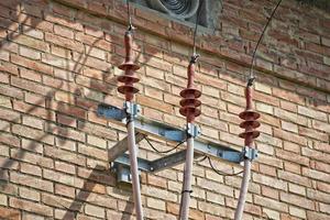 viejos cables de alimentación en la pared de ladrillo foto