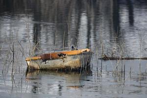 old fisherman boat in a lake in winter time photo