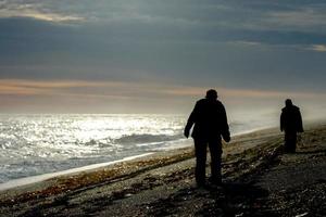 silueta de hombre en la playa al amanecer foto