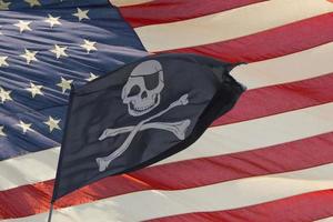 ondeando la bandera pirata jolly roger en american star and stripes foto